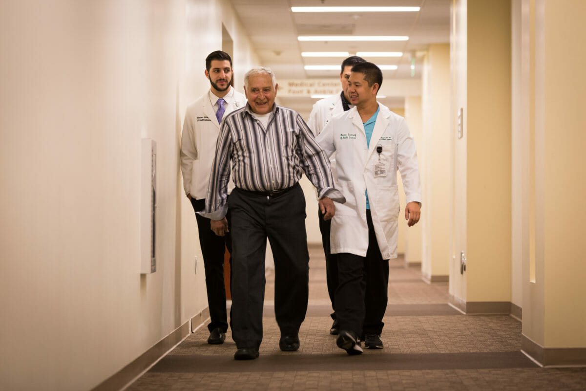 WesternU Health Doctors and patient walking down hall